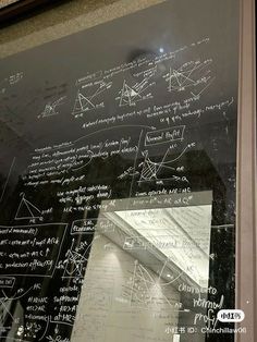 a blackboard with writing on it in a building's glass window sill