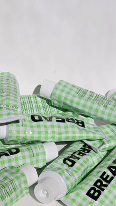 a pile of green and white toothpaste tubes sitting on top of each other