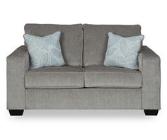 a gray couch with two pillows on it