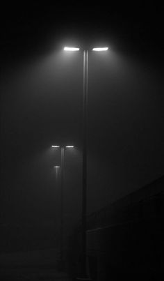 two street lights in the dark on a foggy night