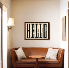 a living room with a couch, table and lamp on the wall next to it