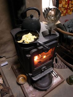 an old fashioned stove with some food cooking on top of it in a living room