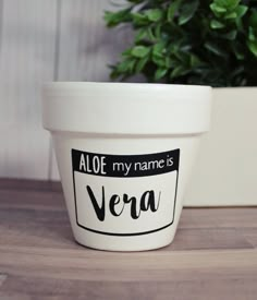 a white pot sitting on top of a wooden table