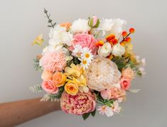 a person holding a bouquet of flowers in their hand