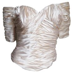 A beautiful off white silk corset top from Vicky Tiel. It is worn off the shoulders with elbow length sleeves, a sweetheart cut neckline and ruching throughout in angles. The front and back hem dip a bit longer in the center. It has vertical boning around it's circumference, is lined in off white silk and has a back zipper. Fits sizes Extra Small, Small. Bust 34" Waist 26" Length 18" Silk Bra Top, Silk Corset Top, Embellished Bodysuit, Silk Corset, Damask Dress, Silk Bodysuit, Silk Bra, Waist Cincher Corset, Bodysuit Top