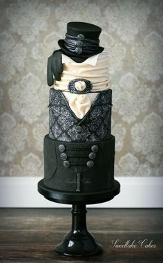 a black and white wedding cake on top of a wooden table