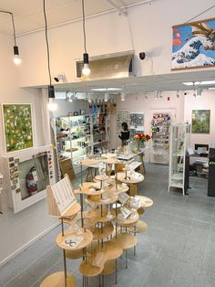 the inside of a craft shop with lots of wooden tables and stools on display