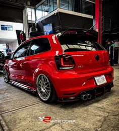 the rear end of a red car parked in a garage