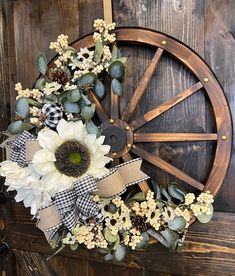 a wreath with sunflowers and other flowers is hanging on a wooden door handle