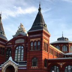 an old red brick building with two steeples on it's sides and snow on the ground