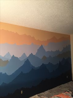 a bedroom with mountains painted on the wall