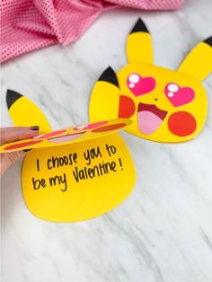 someone is holding up a valentine's day card with a pikachu face on it