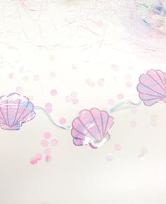 there are three pink seashells hanging on the wall next to polka dot paper