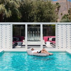 a woman lounging on an inflatable lounge chair next to a pool