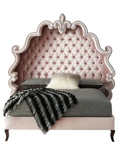 a pink bed with an ornate headboard and foot board