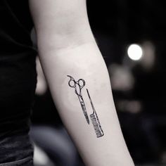 a woman's arm with scissors and combs tattoo on it