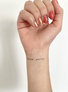 a woman's hand with a small tattoo on her wrist that says, i love you