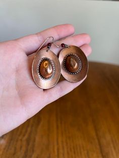 Vintage, large copper cowboy hat earrings. These are so cute and fun, perfect for adding western flare to any outfit. Each earring has a large, genuine copper cowboy hat charm, with a red garnet bead above it. The earrings have stainless fish-hook style ear wire. No earring backs. The hat charm measures1.5" L x 1" W. *ATTENTION* Please ask any questions before purchase, as I do not accept returns OR order cancellations. Thanks for looking! Please follow my Etsy shop, or follow along on Instagram Cowboy Hat Earrings, Cowgirl Jewelry, Western Cowgirls, Western Cowgirl, Cowboy Hat, Red Garnet, Fish Hook, Jewelry For Women, Earring Backs