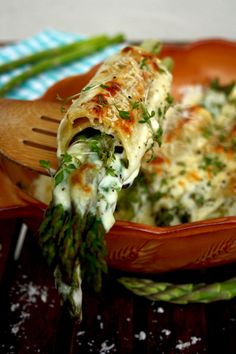 asparagus and cheese enchiladas in a brown bowl