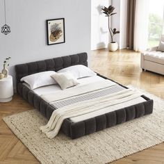 a large bed sitting on top of a wooden floor