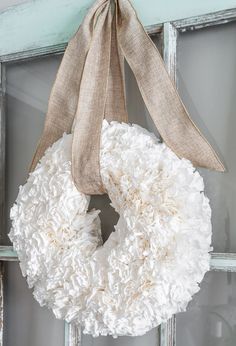 a white wreath hanging on the front door