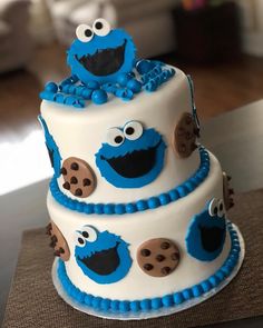 a three tiered cake with blue icing and cookie cookies on it's sides