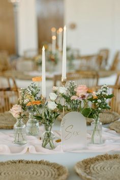 the table is set with flowers and candles