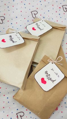 three brown paper bags with tags on them sitting on top of a polka dot tablecloth