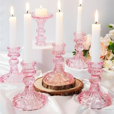 pink glass candlesticks are sitting on a table