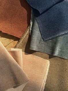 several colors of fabric laid out on top of each other in different sizes and shapes