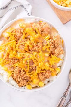 a white bowl filled with mashed potatoes topped with ground beef and cheddar cheese