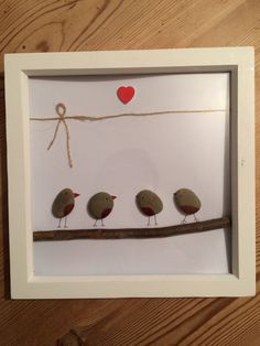 three little birds sitting on a branch with a heart hanging from the line behind them