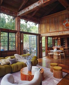 a living room filled with lots of furniture next to a wooden floor covered in windows