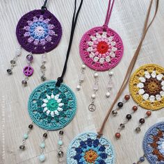 four crocheted medallions are shown on a table with beads and bead necklaces