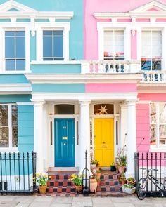 a multicolored house with a bicycle parked in front of the door and steps leading up to it