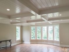 an empty living room with hard wood floors and white walls, windows in the ceiling