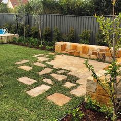 a backyard area with grass and stone blocks