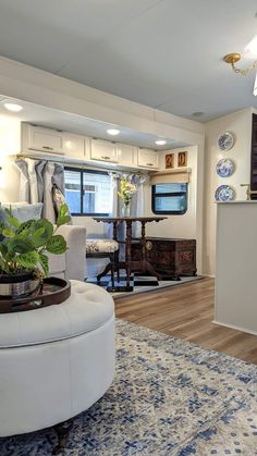 a living room filled with furniture and a large rug on top of a hard wood floor