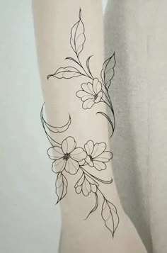 a woman's arm with flowers and leaves tattoo on the back of her leg