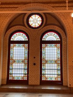 two stained glass windows in the middle of a room