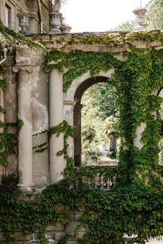 an old building with ivy growing on it's walls and arches in the middle