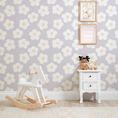 a child's room with flower wallpaper and wooden rocking horse in the corner