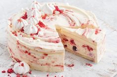 a cake with white frosting and cranberry toppings is cut into pieces