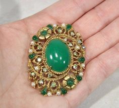 Vintage Florenza Large Green Cabochon Brooch Gold Tone Filigree MISSING STONES Costume Jewelry The large green cabochon seems to be some kind of plastic Roll over clasp closure Measures approximately: 2 1/4" x 1 5/8" Pre-owned vintage. There two missing stones (see first few photos). It is in otherwise beautiful vintage condition. See photos for size and condition. Vintage Yellow Jewelry With Cabochon, Vintage Green Cabochon Jewelry, Vintage Yellow Cabochon Jewelry, Vintage Gold Brooches With Cabochon, Antique Green Gemstone Brooches, Costume Jewelry, Stone Color, Brooch Pin, Gold Tones