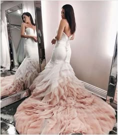 a woman standing in front of a mirror wearing a dress with ruffles on it