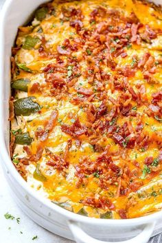 a white casserole dish filled with bacon, cheese and jalapenos