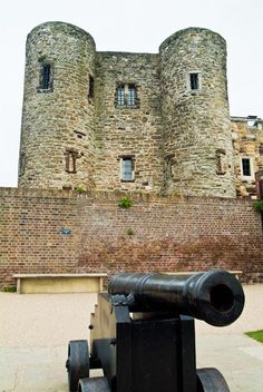 an old cannon is sitting in front of a castle