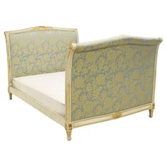 an antique style daybed with blue and gold damask upholstered fabric on it