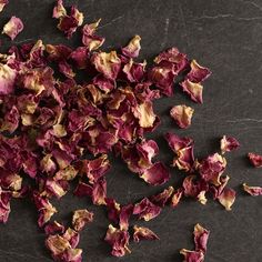 dried rose petals on a black surface