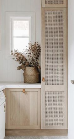 a kitchen with white walls and wooden cabinets